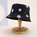 Kinder-Anglerhut in Schwarz mit lila lächelnden Blumenmustern auf Holzständer - Kinder 54cm / Blume Schwarz