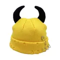 Detail of yellow knit beanie with black devil horns, safety pin and metal ring accents - One Size / Yellow