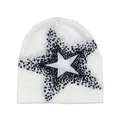 Close-up of a white knit beanie with a pixelated black star design for winter fashion - White