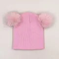 Pink winter knit hat for girls with two fluffy faux fox fur pom-poms on a light background - One Size / Pink