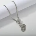 Detailed macro of a silver-tone tennis chain necklace with a crystal heart and G pendant - Silver Set G