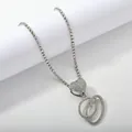 Macro detail of silver tennis chain with heart clasp and iced out letter D pendant - Silver Set O