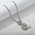 Macro shot of silver letter Q pendant with heart link and iced out tennis chain - Silver Set Q
