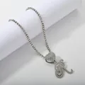 Macro detail of iced out tennis chain with heart pendant and sparkling cursive letter R - Silver Set R