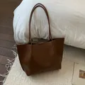 Vue détaillée de la texture du cuir synthétique marron grainé sur un grand sac cabas - Sans pendentif / Marron