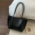 Détail du grand sac cabas en cuir noir grainé avec de fines bretelles et une doublure - Sans pendentif / Noir