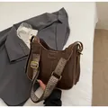 Detalle del bolso de hombro en cuero PU marrón con logo grabado y correa ancha tejida - Marrón