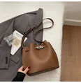 Detailed view of brown litchi leather bucket bag with silver twist lock and adjustable strap - No Pendant / Brown