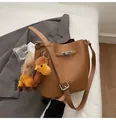 Detail of brown lychee leather bucket bag with silver buckle and camel plush charm - Apricot With Pendant