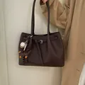 Detalle de bolso tote de cuero granulado marrón oscuro con colgantes de perro y béisbol - Con Colgante / Marrón