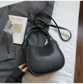 Detail of black pebble leather handbag with silver hardware and adjustable strap - Black