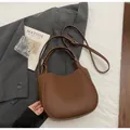 Detailed view of dark brown lychee grain leather bucket bag with silver hardware accents - Brown