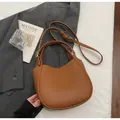 Detail shot of brown lychee grain leather handbag on elegant lifestyle background - Brown