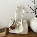 Detail der cremeweißen Tote Bag aus genarbtem Leder mit braunem Dackel-Anhänger - Weiß mit Anhänger
