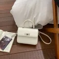 Detail of white PU leather square handbag featuring silver metal twist lock and top handle - Standard Type / White