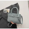 Primer plano de bolso de cuero azul claro con costuras finas y detalle de hebilla de metal - Sin colgante / 22*8*15 / Azul
