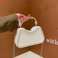 White leather shoulder bag with silver stud trim and a metallic curved top handle - White
