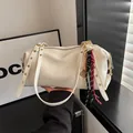 White textured leather shoulder bag with gold buckles and colorful woven rope charm - With Pendant / Off White