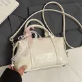 Chic cream white glossy crossbody pillow bag with embossed text and lace bow detail - No Pendant / White