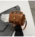 Vintage brown leather crossbody bag with a round metal buckle and top handle detail - Brown
