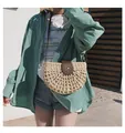 Detail der handgewebten Strohsatteltasche mit brauner Lederklappe und Schnalle am Model - Beige