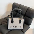 Canvas tote bag in beige with black leather trim and PARIS lettering on quilted seat - Small / Black