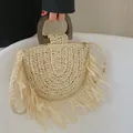 Beige halbrunde Stroh-Handtasche mit Fransen und dunklem Holzgriff für den Sommerstrand - Gebrochenes Weiß