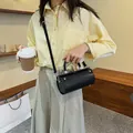 Fashionable black cylindrical handbag in matte leather with silver studs and top handle - Black