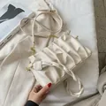 Chic beige ruched cloud bag with woven handle and gold chain strap in minimalist setting - Off White