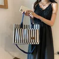 Sac fourre-tout en toile à rayures verticales bleues et blanches avec écusson en cuir brun - Bleu