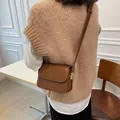 Borsa a tracolla marrone con dettagli dorati mostrata su modella vista posteriore - caffè