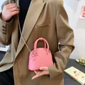 Pink lychee grain shell bag with silver chain strap and top handle on casual blazer - Pink