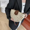 Beige semicircular woven straw crossbody bag with brown leather flap and silver buckle - White