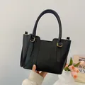 Fashionable black lychee leather bucket bag with gold hardware and top handles - Black