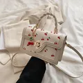 Borsa a tracolla color crema con motivo a ciliegie rosse e manico intrecciato - Bianco