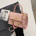 Pink crossbody handbag with embossed cartoon patterns and gold hardware in a soft setting - Pink Without Pendant