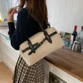 Beige Boston bag with black leather straps and gold buckles in a kitchen scene - Khaki