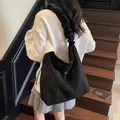 Retro black matte tote bag with ruffled shoulder strap shown on a model in minimalist style - Black