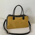 Detalle del bolso Boston bicolor con gamuza amarilla y correas de cuero negro fino - Amarillo