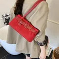 Red suede shoulder bag with gold square buckles and vintage strap details - Red