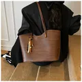 Detail of dark brown woven tote bag with wavy rim and colorful wooden bead tassel accessory - With Beaded Pendant / Brown