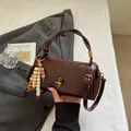 Deep brown cylinder crossbody bag with vintage gold clasp and multicolor wooden beads - With Charm / Brown