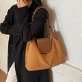Brown frosted suede tote bag with leather straps on model in a minimalist setting - Brown