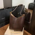 Sac à bandoulière tressé marron foncé avec anse arrondie et détails métalliques dorés - Style de Base / Marron