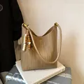 Sac fourre-tout marron à texture tissée avec pompon perlé sur une valise argentée - Style Avec Pendentif / Kaki