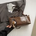 Borsa sottobraccio in pelle verniciata marrone lucida con ciondolo baseball e logo Cleard K - Con ciondolo sportivo / caffè