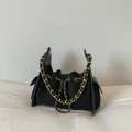 Detail van zwarte gewatteerde suède tas met gouden ketting en trekkoordsluiting - Zwart