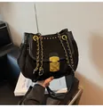 Detalle de bolso de hombro de ante negro con textura plisada y correa de cadena dorada - Talla única / Negro