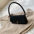 Minimalistische schwarze Leder-Achseltasche mit goldenem Verschluss und schmalem Gurt - Schwarz
