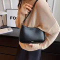 Minimalist black crescent shoulder bag with golden logo and adjustable strap for women - Black